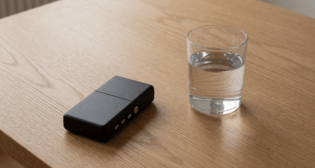 Opnameapparaat en een glas water op een tafel in een verhoorkamer
