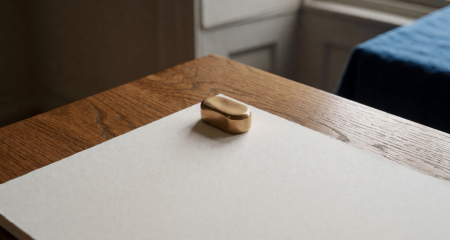 Contractpagina onder een koperen gewichtje op een eikenhouten bureau