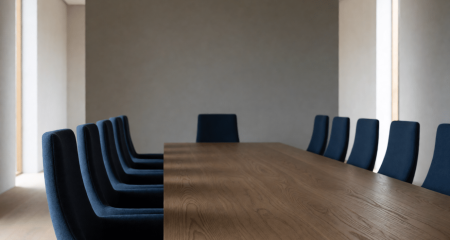 Formele bestuurskamer met een lange tafel en hoge stoelen