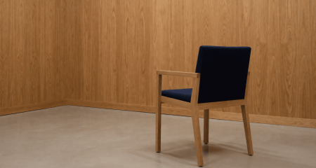Losse stoel tegenover een houten lambriseringswand