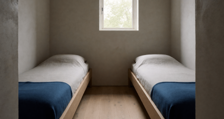 Kleine kamer met twee smalle bedden tegen tegenoverliggende muren