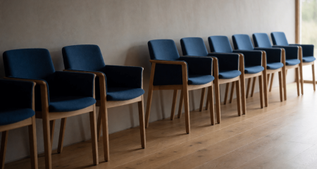 Rij identieke bureaustoelen met een lege plek ertussen