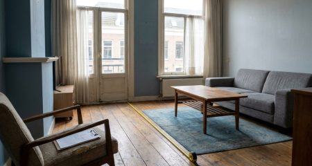 Lege huurwoning met een meetlint over de vloer en een klembord met inspectieformulier