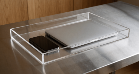 Telefoon en laptop in een doorzichtige bewijsbak op een metalen tafel