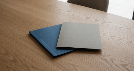 Twee documentmappen die elkaar overlappen midden op een eikenhouten tafel