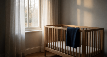 Leeg houten ledikant in een rustige babykamer bij het raam