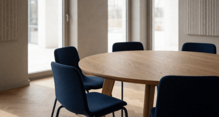 Overlegruimte op school met een ronde tafel en lege stoelen