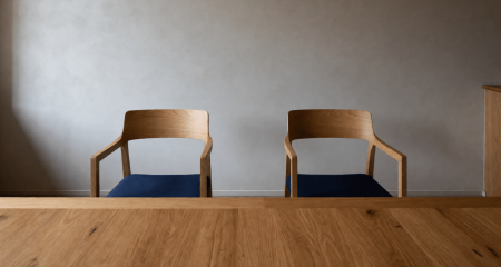 Twee stoelen aan een rechtszaaltafel met slechts één map ervoor