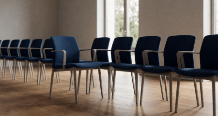 Rij identieke bureaustoelen met één stoel uit het gelid