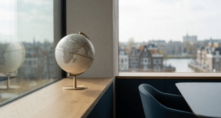 Modern kantoor met een wereldbol op de vensterbank en stadsuitzicht