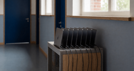 Laptopkar met opladende apparaten in een schoolgang