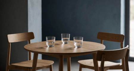 Drie stoelen rond een ronde tafel met drie waterglazen