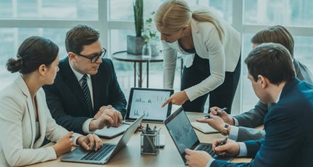 Een groep zakelijke professionals bespreekt documenten en financiële rapporten tijdens een vergadering in een modern kantoor.