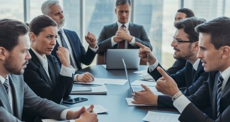 Een groep zakelijke professionals in een vergaderruimte die gespannen en in discussie zijn, met blikken van frustratie en conflicten.