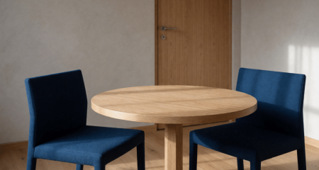 Twee stoelen tegenover elkaar aan een tafel in een spreekkamer