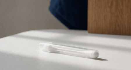 Wattenstaafje in een verzegeld buisje op een schoon wit oppervlak