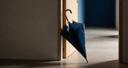 Paraplu tegen een kantoordeur met daglicht erdoorheen