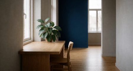 Klein bedrijfskantoor met een bureau, plant en een lege stoel
