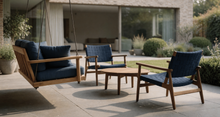 Tuinschommel en twee stoelen op een terras bij een gezinswoning